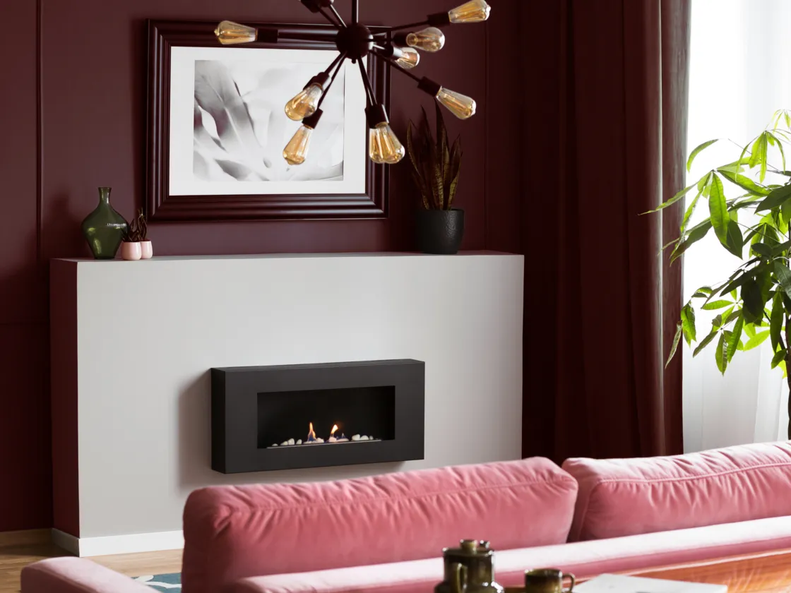 A sophisticated living room with a rich, burgundy wall, modern fireplace and pink velvet couch